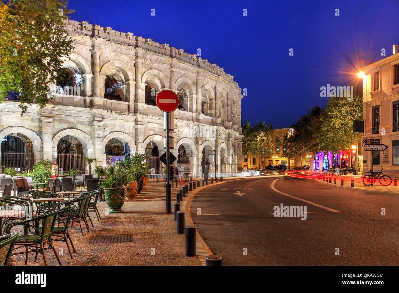 Nacht in Nîmes, Frankreich mit der wunderschönen römischen Arena, die über dem Bd des Arènes thront. Stockfoto