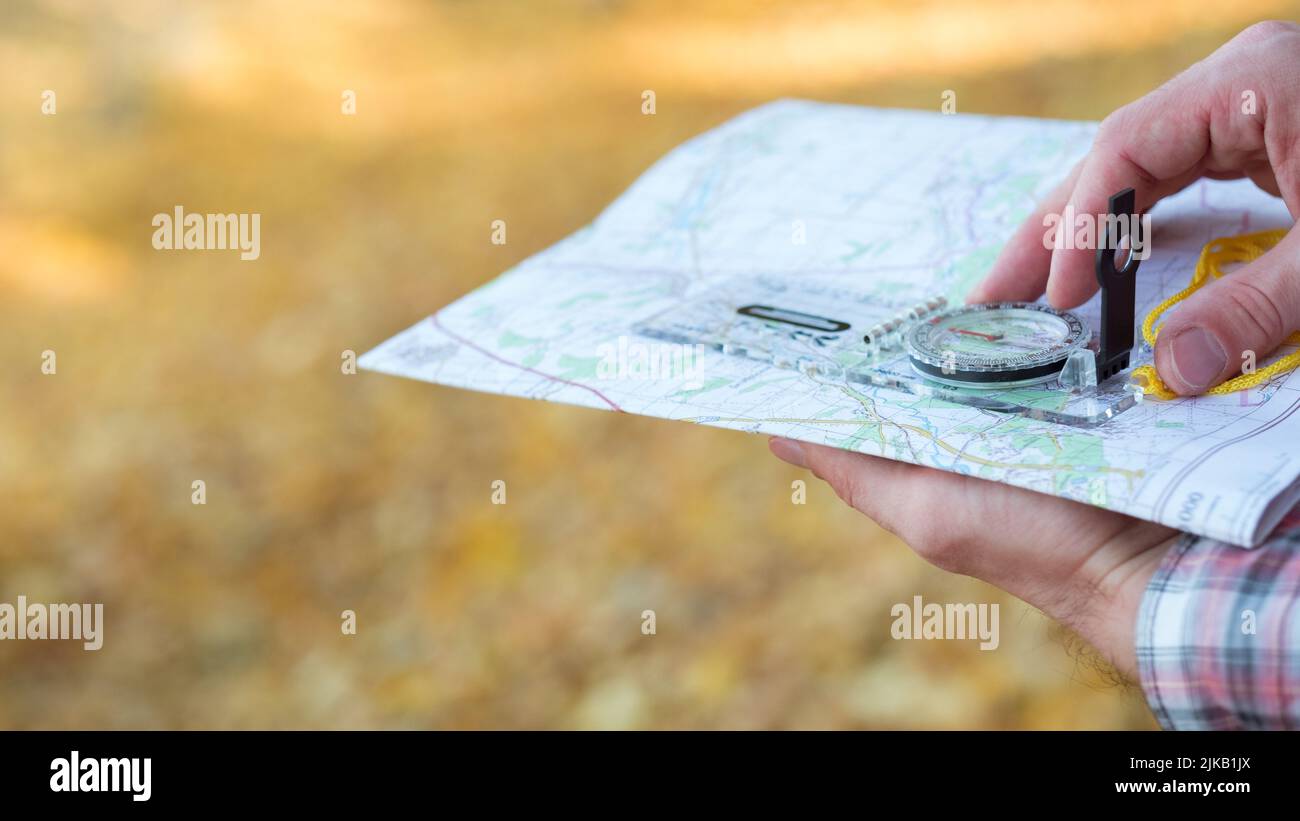 Reisender Lebensstil Mann Kompass Karte gelben Gras Stockfoto