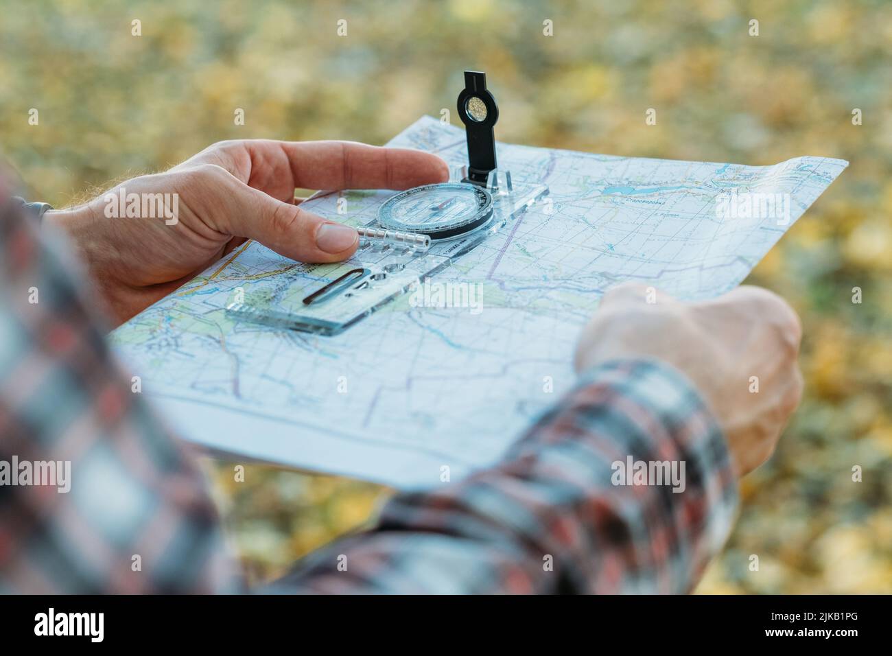 Herbst Reise Mann Kompass Karte gelbes Gras Stockfoto