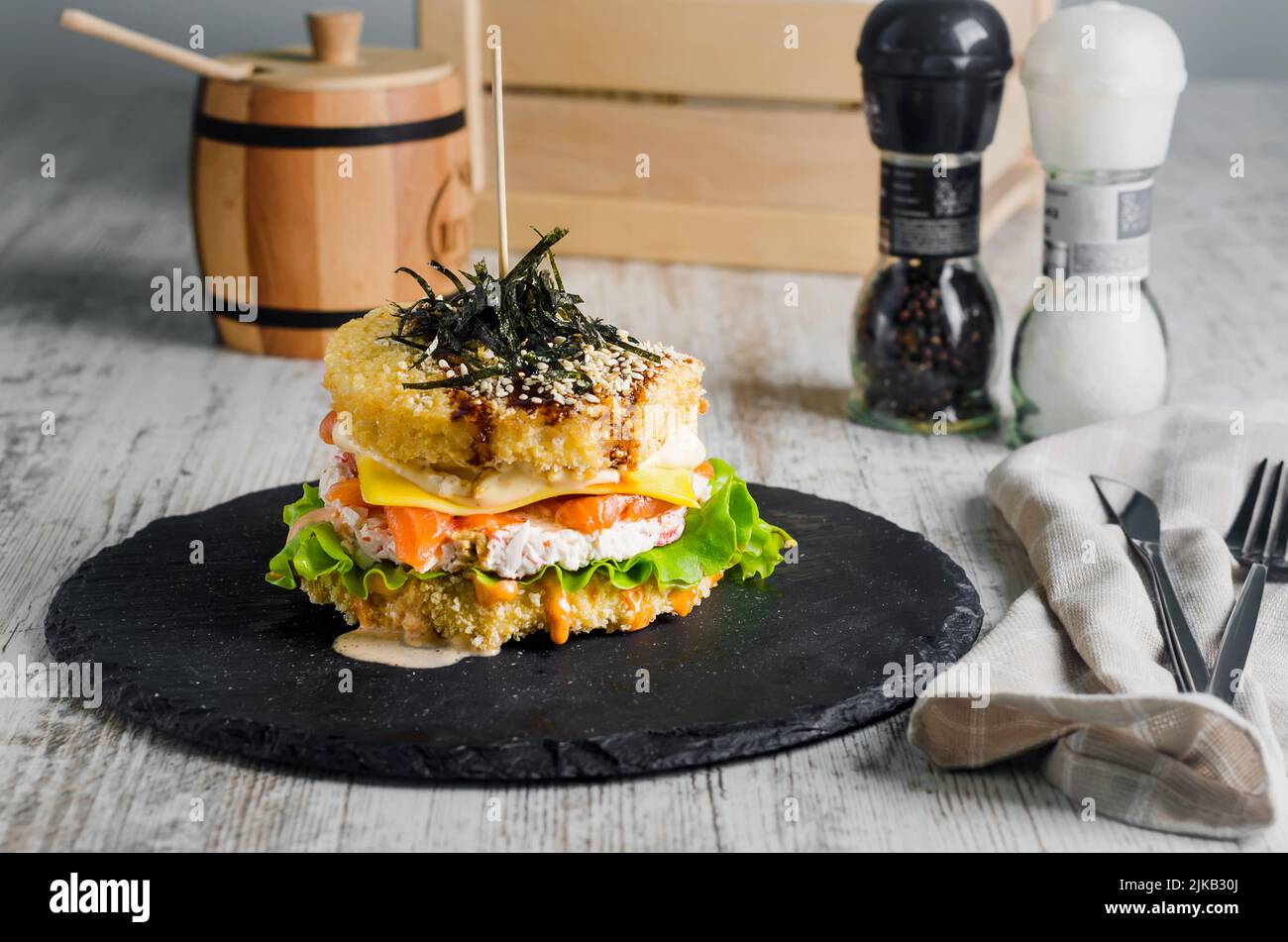 Sushi-Burger aus Reisbrot mit Lachs, Salat und Wasabi-Sauce. Sushi-Food Hybriden Trend. asiatische Stil glutenfrei. Stockfoto