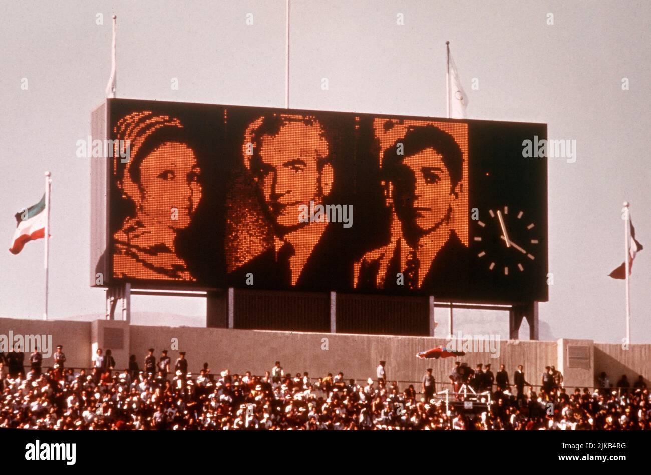 EL SHA DE PERSIA SU MUJER Y SU HIJO EN UNA PANTALLA GIGANTE DEL ESTADIO. Lage: AUSSEN. Nación. IRAN. FARAH PAHLAVI. SHA DE PERSIA. PALHAVI REZA MOHAMED. REZA PAHLEVI MOHAMED. REZA PAHLAVI II 1960/. REZA CIRO 1960. PALHEVI REZA. Stockfoto