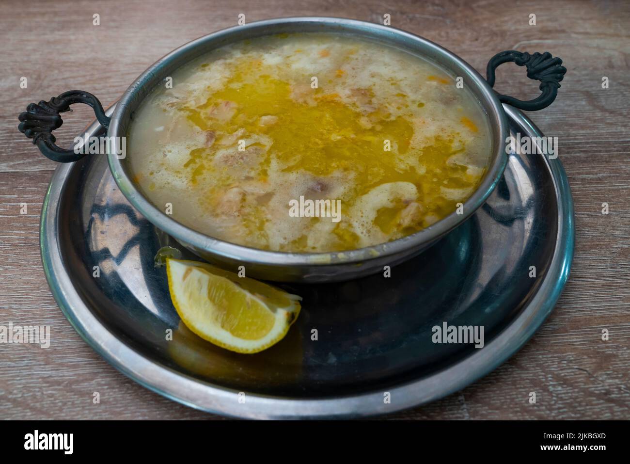Kutteln-Suppe in einer Kupferschüssel mit Zitrone Stockfoto