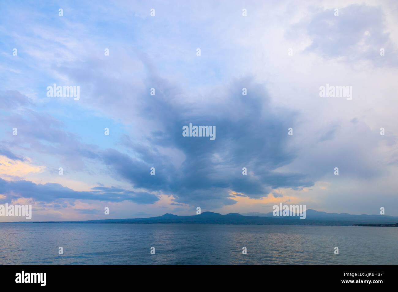 Sevan See und die umliegenden Berge an einem bewölkten Sommertag, bei Sonnenuntergang Stockfoto