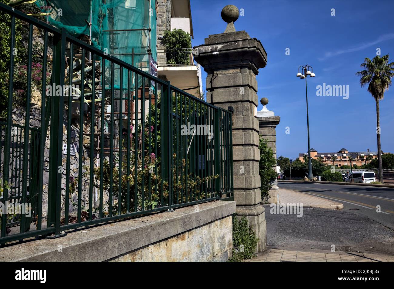 Zaun und Zugang neben einer Straße am Meer an einem sonnigen Tag Stockfoto