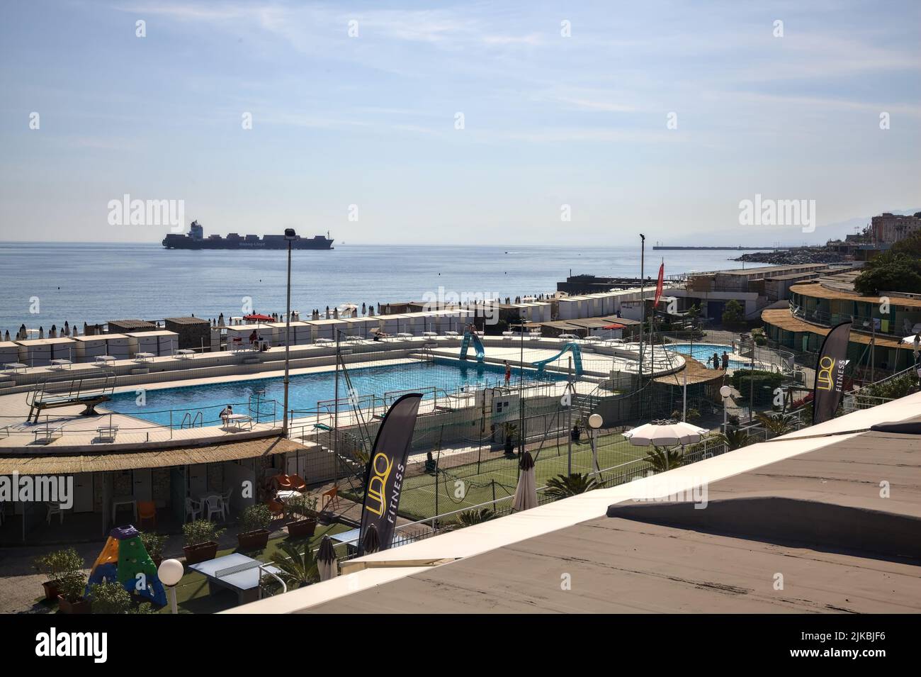 Frachtschiff, das an einem klaren Tag neben einem Strand vorbeifährt Stockfoto