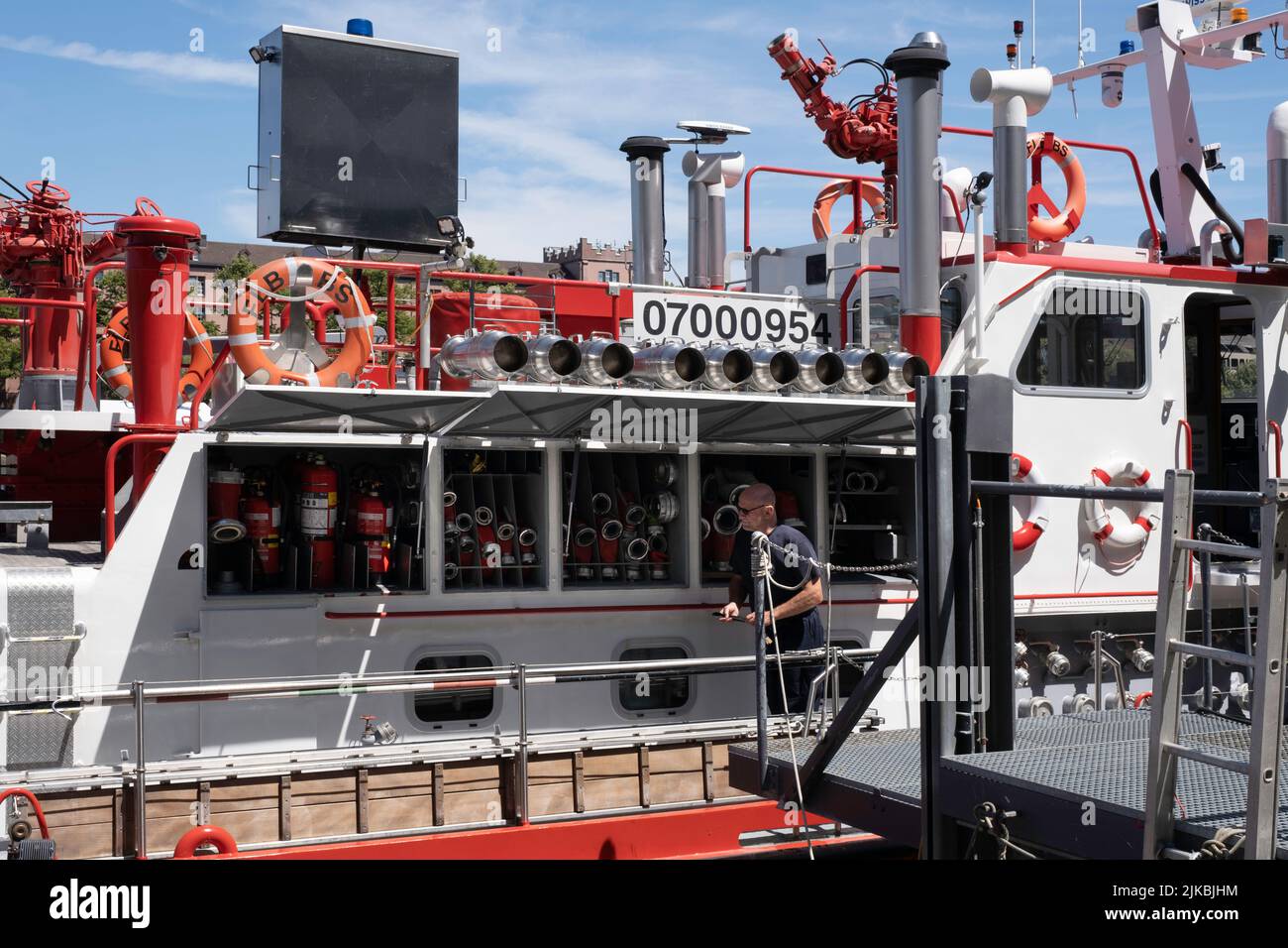 Detail des rot-weißen Feuerlöschbootes namens Christophorus mit Feuerwehrmann, der im Sommer am Rheinufer in der Stadt Basel festgemacht wurde Stockfoto