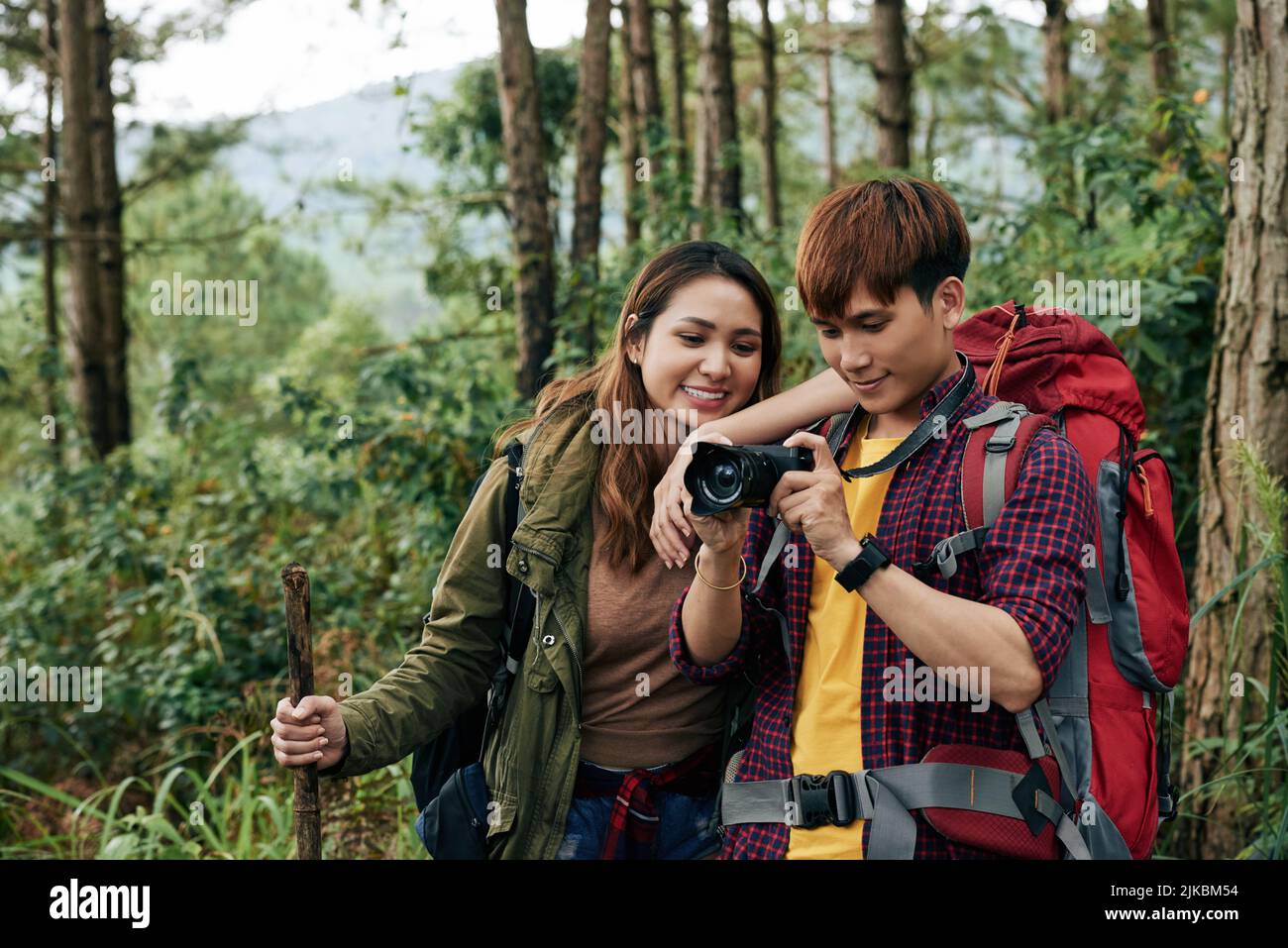 Vietnamesisches Paar von Reisenden, die im Wald spazieren und Fotos machen Stockfoto