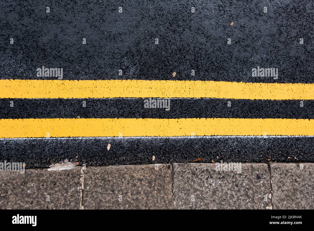 Doppelte gelbe Markierung auf britischen Straßen Stockfoto