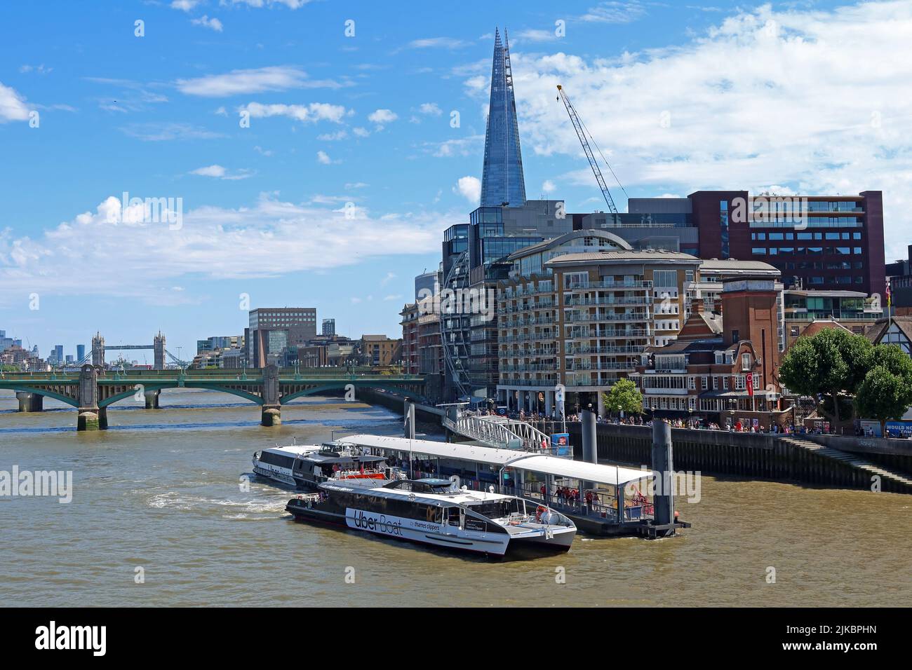Bankside, Thames Clipper Uber Boat und Shard / Tower Bridge hinter sich, Blick nach Osten, von der London Bridge City Haltestelle Stockfoto