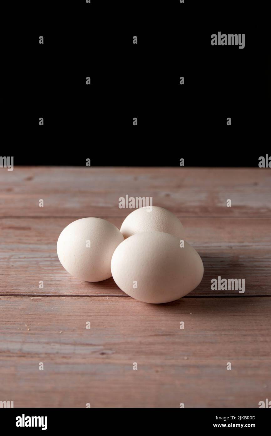 Frische Freilandeier von der Hühnerfarm auf einem Holztisch im Hintergrund Stockfoto