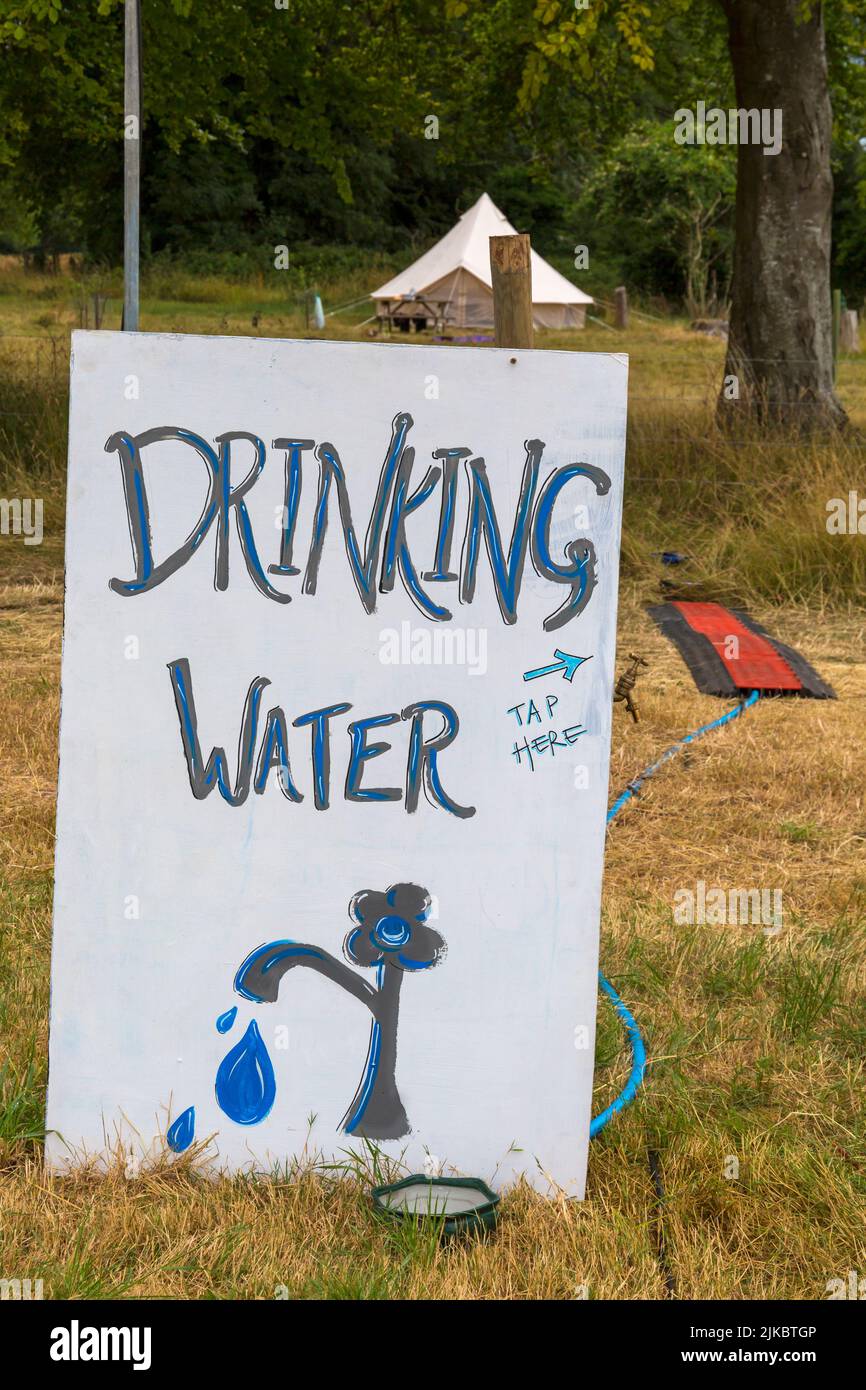 Trinkwasser Zeichen Wasserhahn hier Zeichen in Chettle Village Fete, Chettle, Dorset UK im Juli Stockfoto