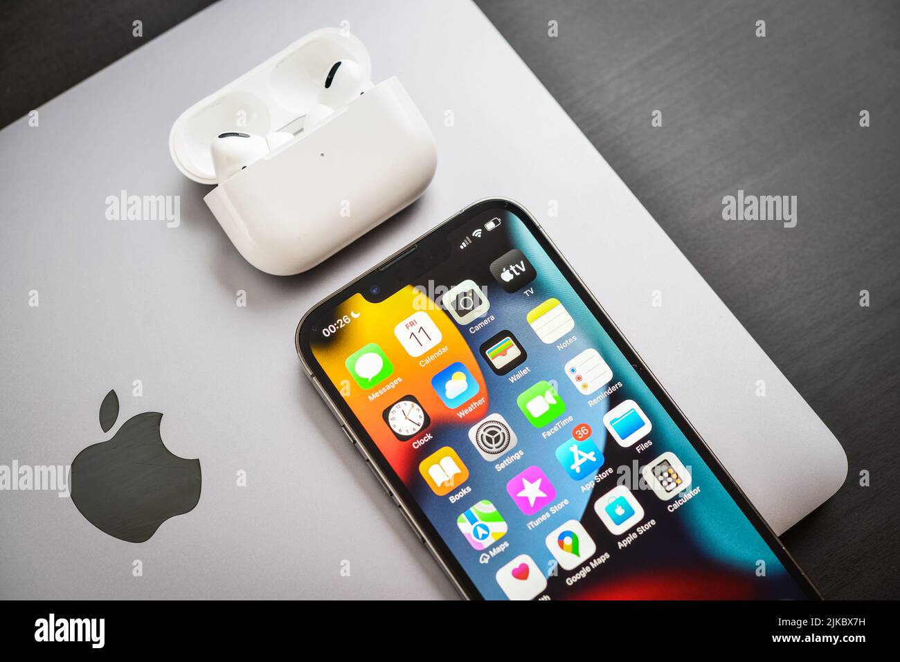 KIEW, UKRAINE - 10. FEBRUAR 2022: Apple-Produkt. MacBook Pro, iPhone 13 Pro mit AirPods Pro Kopfhörern auf schwarzem Hintergrund Draufsicht. Technologie-ga Stockfoto