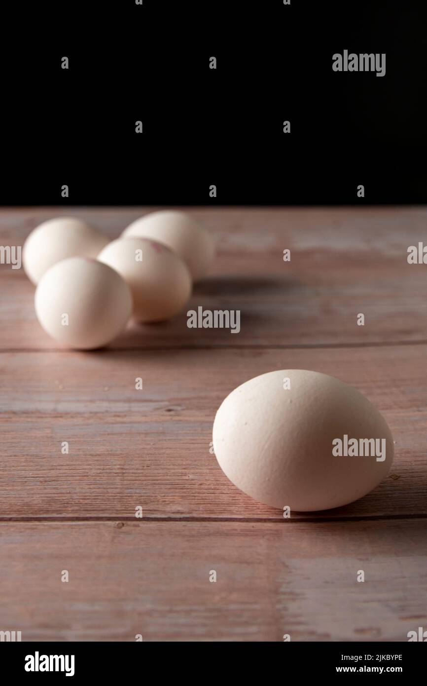 Frische Freilandeier von der Hühnerfarm auf einem Holztisch im Hintergrund Stockfoto