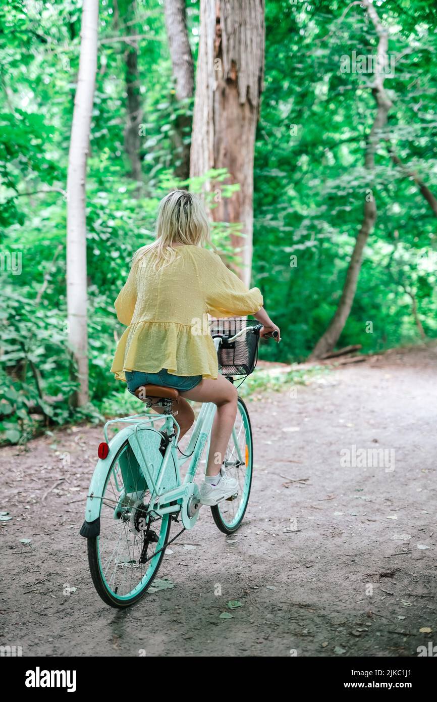 Junge blonde Mädchen im Begriff, ein Fahrrad auf einem Trail Sommer draußen zu fahren Stockfoto