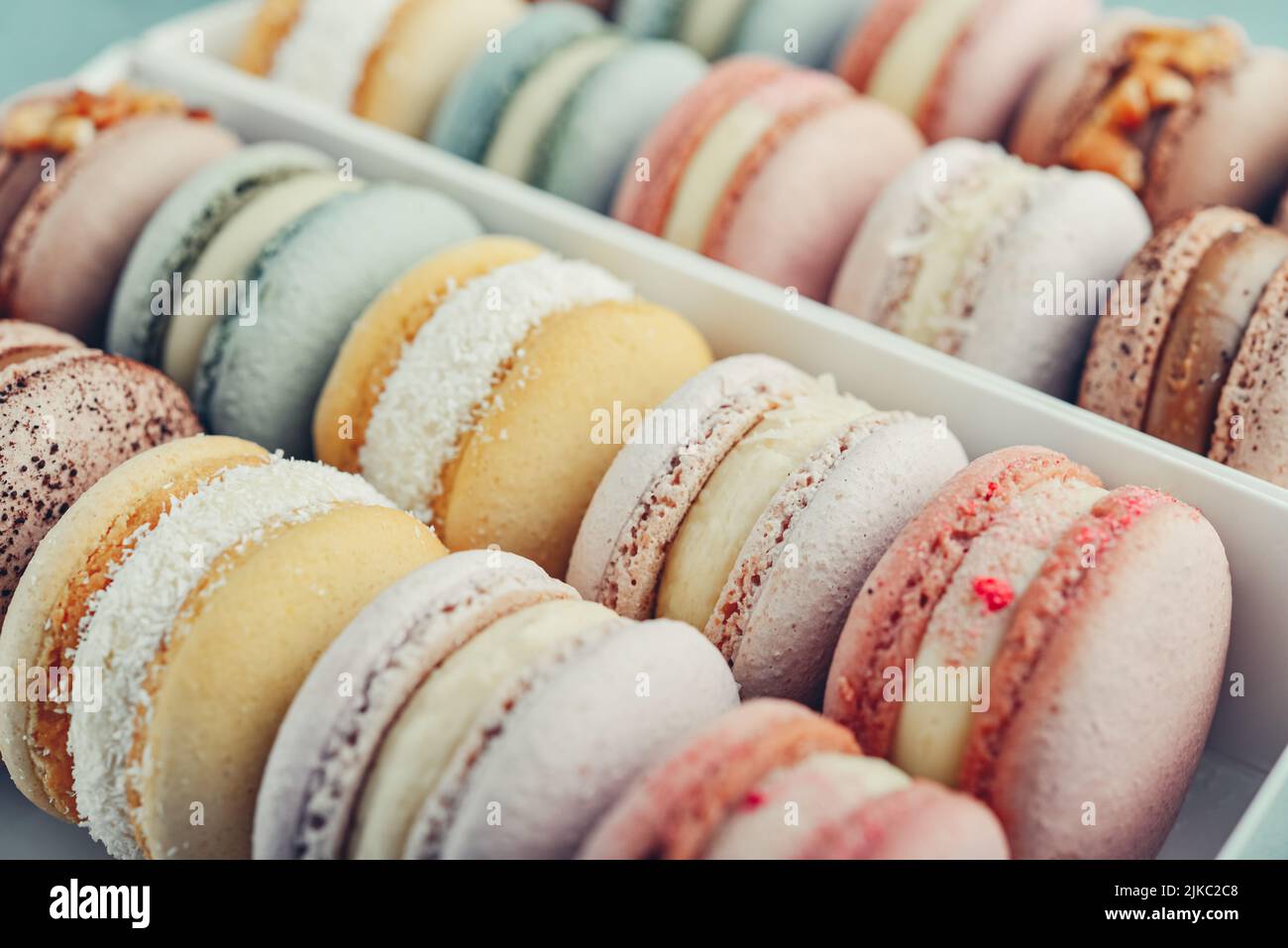 Farbenfrohe französische Macarons im Hintergrund, Nahaufnahme. Leckere süße Farbe Makronen. Bäckerkonzept.Selektiver Fokus. Stockfoto
