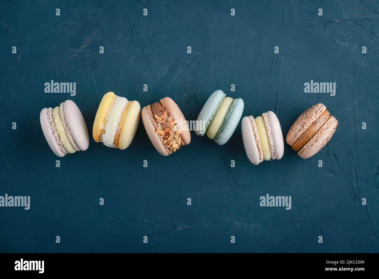 Bunte Macarons auf blauem Hintergrund, Draufsicht Stockfoto