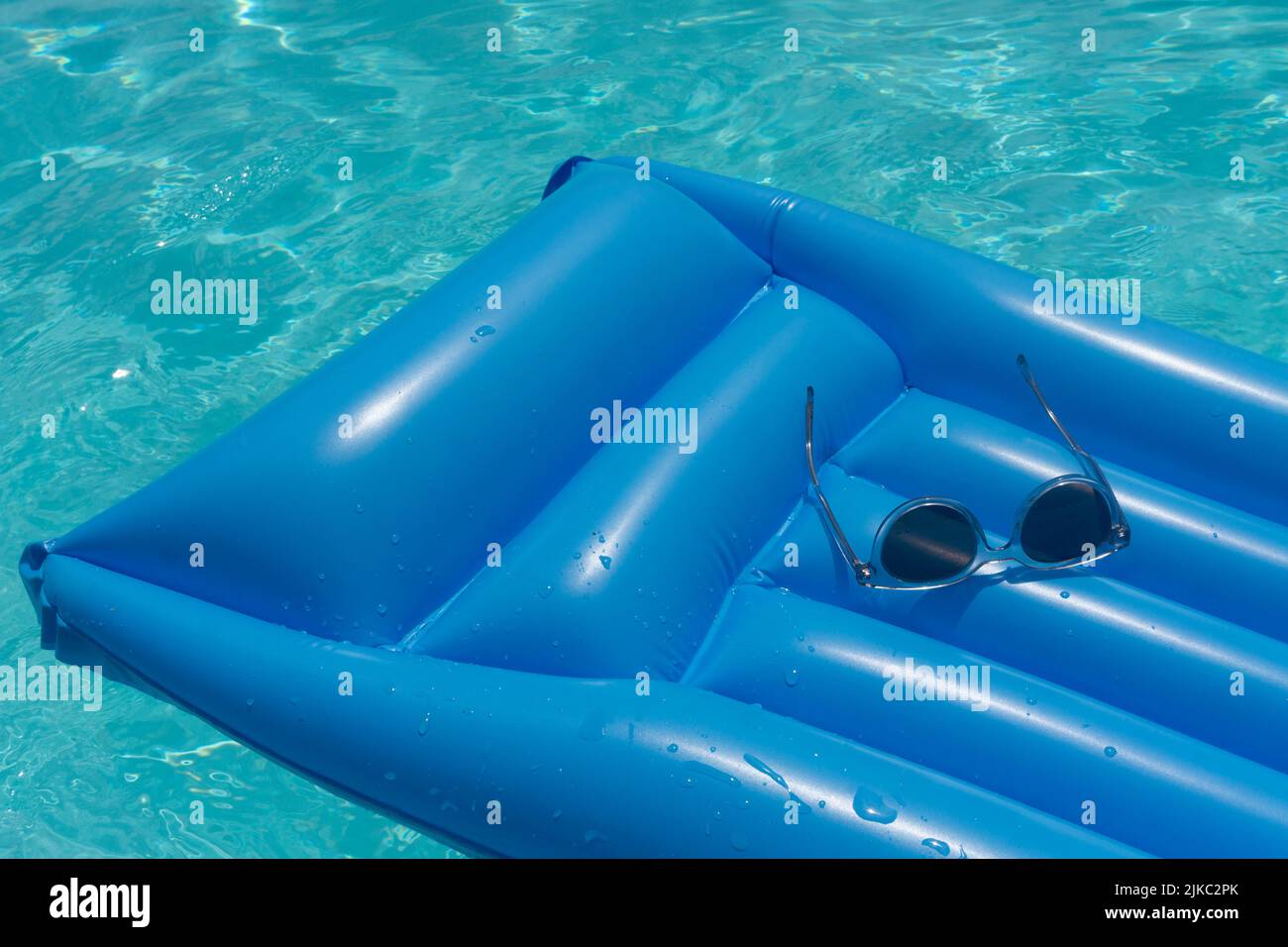 Sonnenbrillen auf einem blauen Schwimm-Schwimmer. Sommerferien Hintergrund Stockfoto