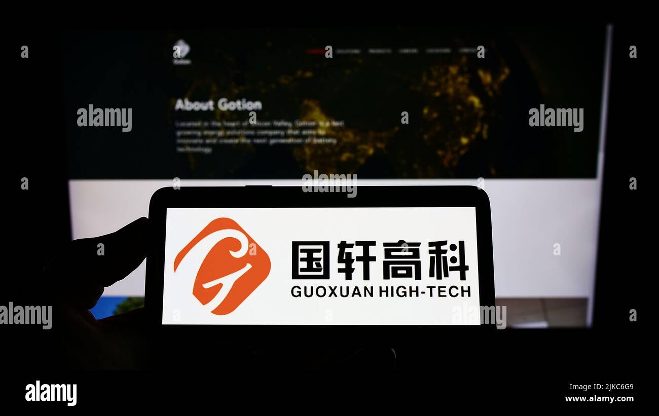 Person, die das Smartphone mit dem Logo des chinesischen Batterieunternehmens Gotion High-Tech auf dem Bildschirm vor der Website hält. Konzentrieren Sie sich auf die Telefonanzeige. Stockfoto