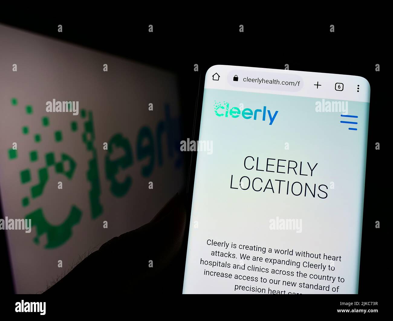 Person, die Mobiltelefon mit der Webseite des US-Gesundheitsunternehmens Cleerly Inc. Auf dem Bildschirm vor dem Logo hält. Konzentrieren Sie sich auf die Mitte des Telefondisplays. Stockfoto
