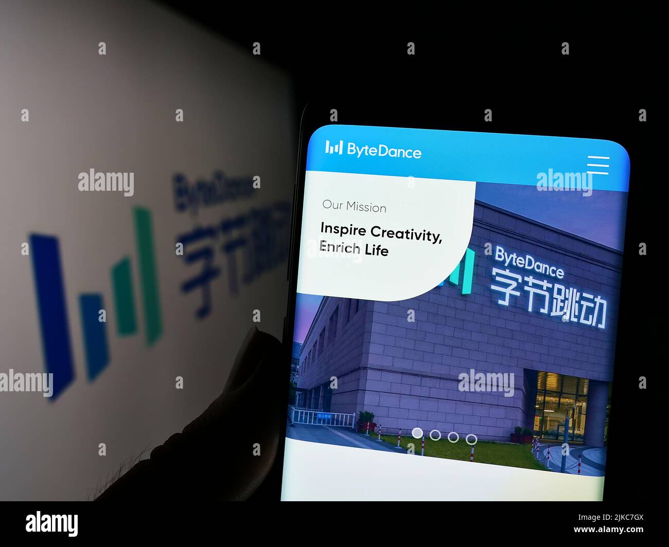 Person, die Mobiltelefon mit der Website des chinesischen Technologieunternehmens Bytedance Ltd. Auf dem Bildschirm vor dem Logo hält. Konzentrieren Sie sich auf die Mitte des Telefondisplays. Stockfoto