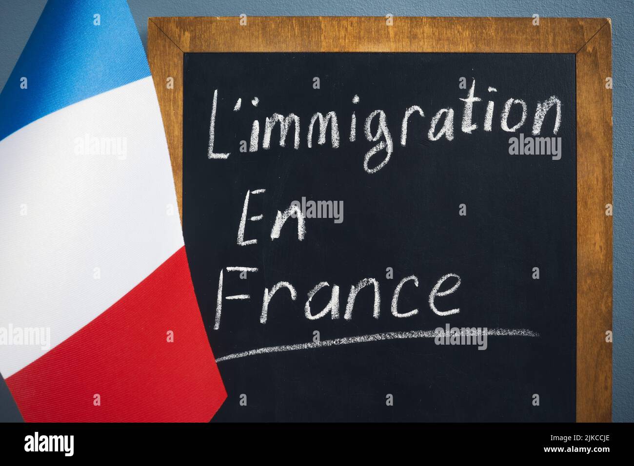 Flagge und Inschrift Einwanderung nach Frankreich auf einer Tafel. Stockfoto