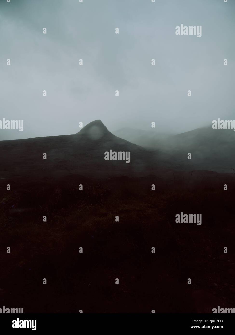 Eine bewölkte, dunkle, unfruchtbare, dramatische, niedrig bewölkte Berglandschaft in den West Highlands von Schottland UK - launische, dunkle Landschaft mit minimalem Hintergrund Stockfoto