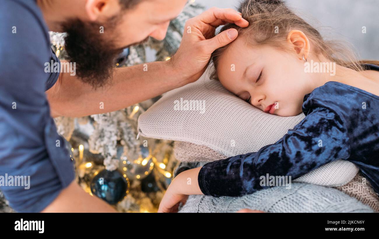 weihnachtsmorgen Vater kleine Tochter schläft Stockfoto