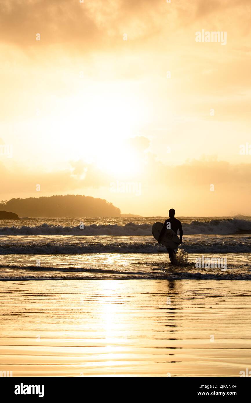 Surfer beim Sonnenuntergang am Strand in Tofino, British Columbia Stockfoto