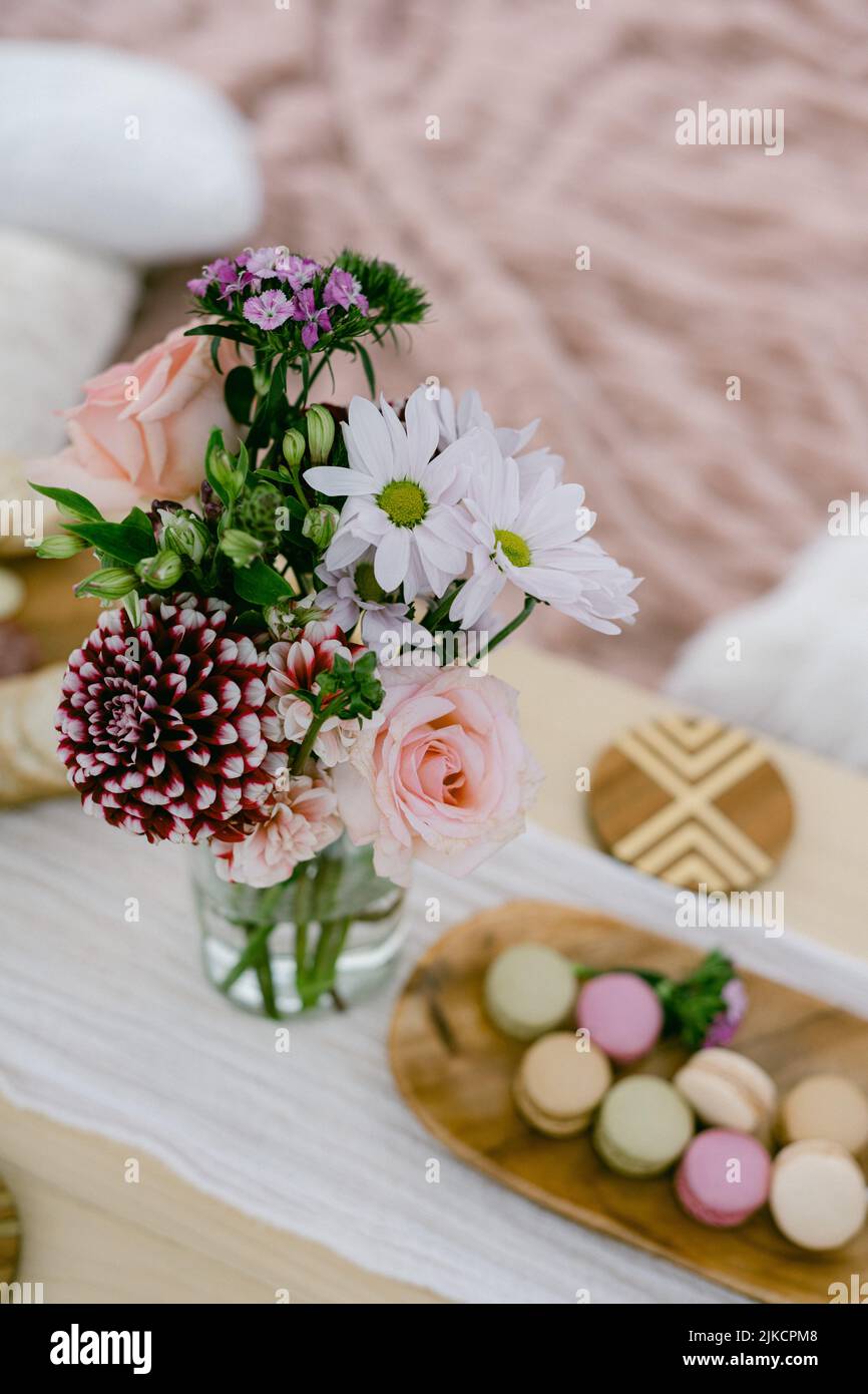 Blumen und Macarons auf einem Picknick-Setting Stockfoto