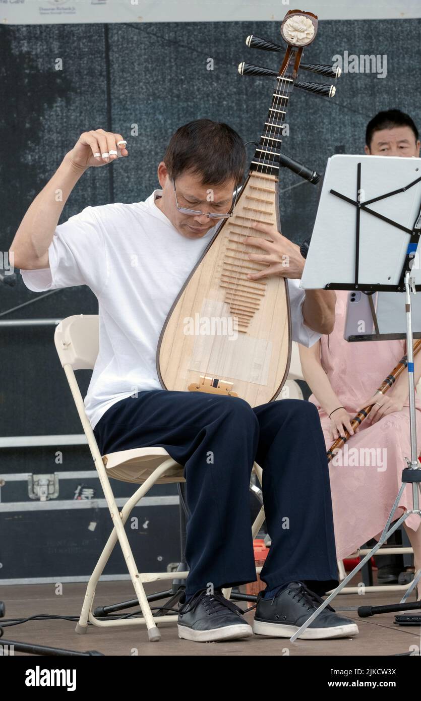 Ein Mitglied des Chinese Music Ensemble of New York spielt die Pipa, ein traditionelles chinesisches Instrument. Auf dem Hong Kong Dragon Boat Fest in Queens, NYC. Stockfoto