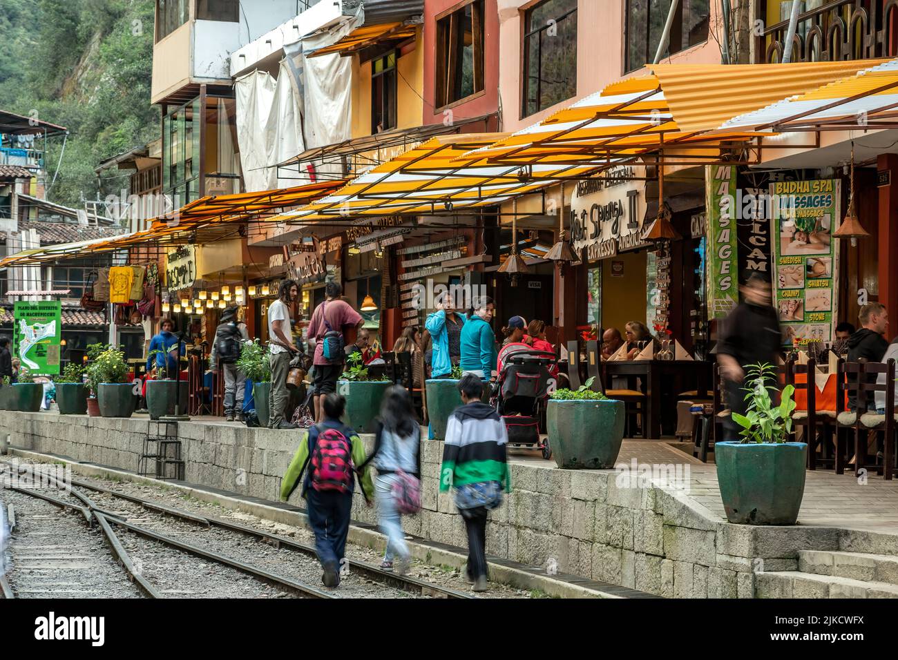 Restaurantreihe, Menschen- und Bahnstrecken, Aguas Calientes, aka Machu Picchu Pueblo, Urubamba, Cusco, Peru Stockfoto