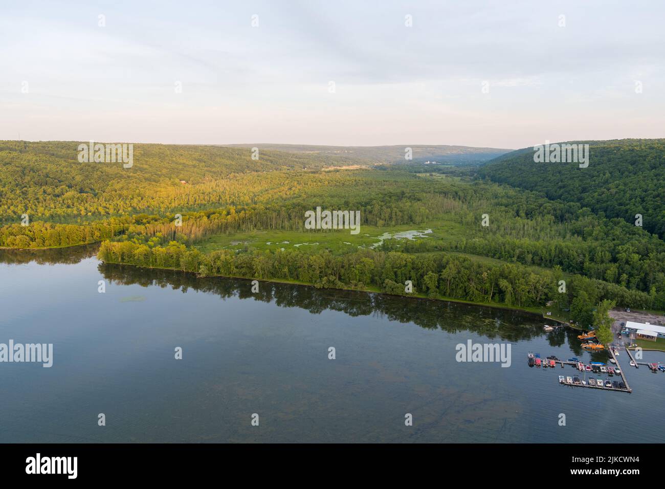 Am späten Nachmittag scheint die Sonne auf dem Owasco See und dem Owasco Inlet in der Nähe von Moravia, Cayuga County, New York. Ein kleiner Yachthafen befindet sich auf der rechten Seite. Stockfoto