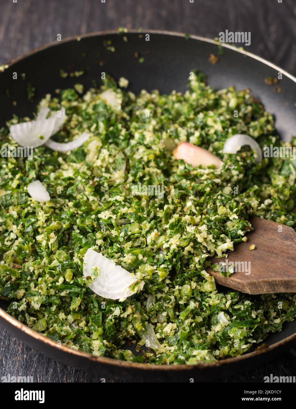 Gesunder Gemüsesalat in der Pfanne mit einem Löffel, gehackter Kohl gemischt mit geriebener Kokosnuss, weicher Hintergrund Stockfoto