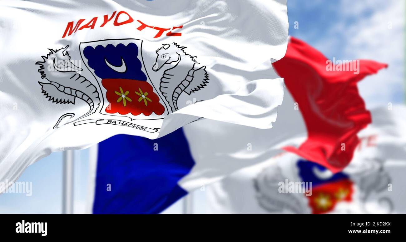 Flaggen von Mayotte winken im Wind mit der französischen Nationalflagge an einem klaren Tag. Mayotte ist ein überseeisches Departement und eine Region und ein einziges territoriales c Stockfoto