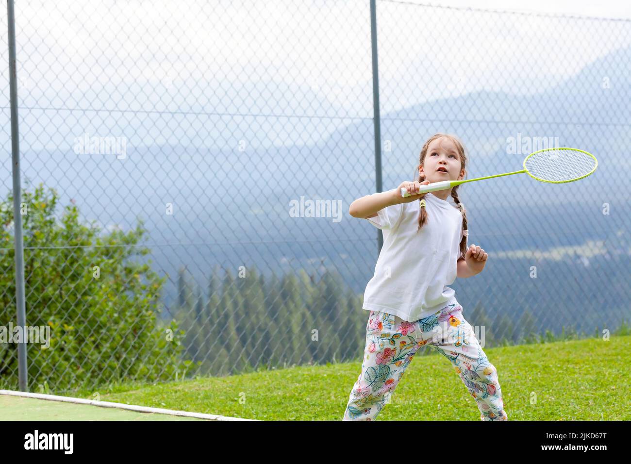 Glücklich sportliche Grundschulalter Kind, Mädchen spielen Badminton im Freien Action shot, Copy Space, eine Person. Kinder und Sport gesunde Lebensweise und Stockfoto