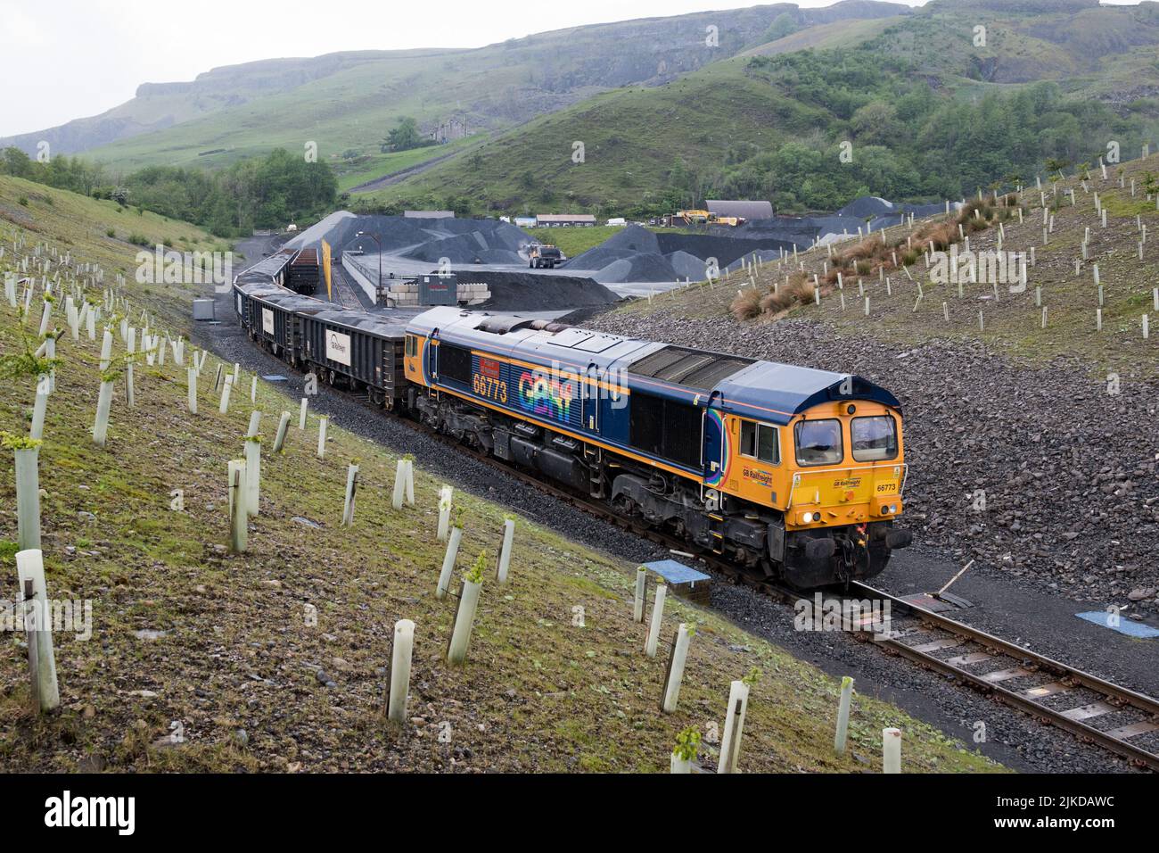 Eine Diesellokomotive der Klasse 66 mit einem Zug aus Steinwagen, die im Arcow Quarry, Helwith Bridge, North Yorkshire, verladen wird. Stockfoto