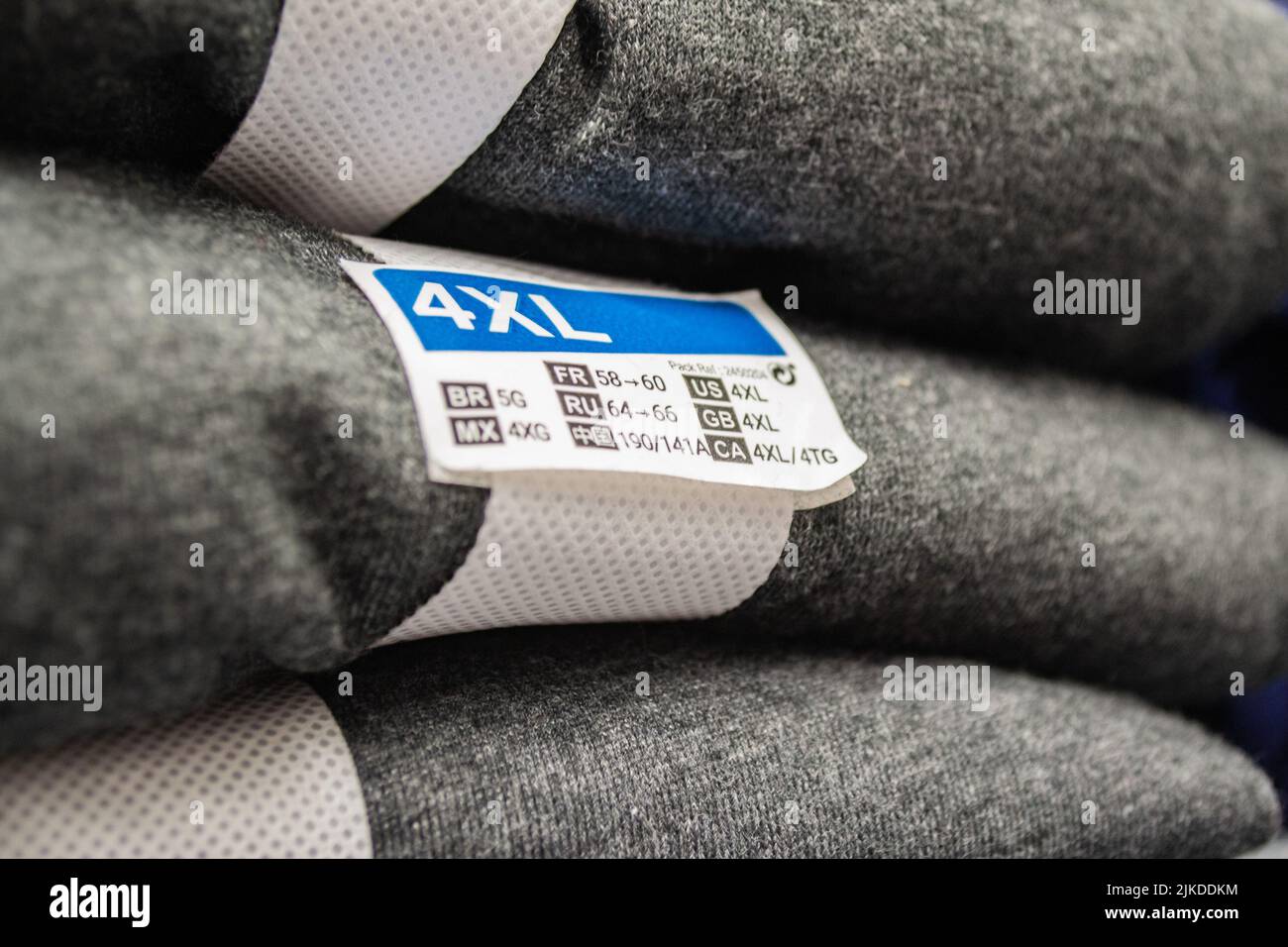 Ein Stapel grauer Kleidung mit dem Größenetikett 4XL Stockfoto