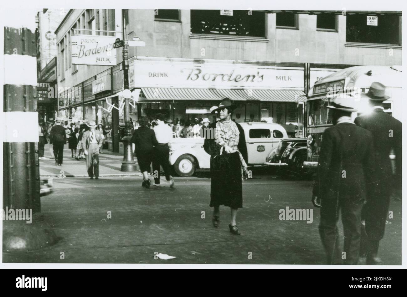 Frau, die die Straße in Harlem an der West 125. Street und Eighth Avenue, 1939 überquert. Grossman, Sid (Fotograf). Straßenszenen Harlem, 1900-1970s Harlem, Stockfoto