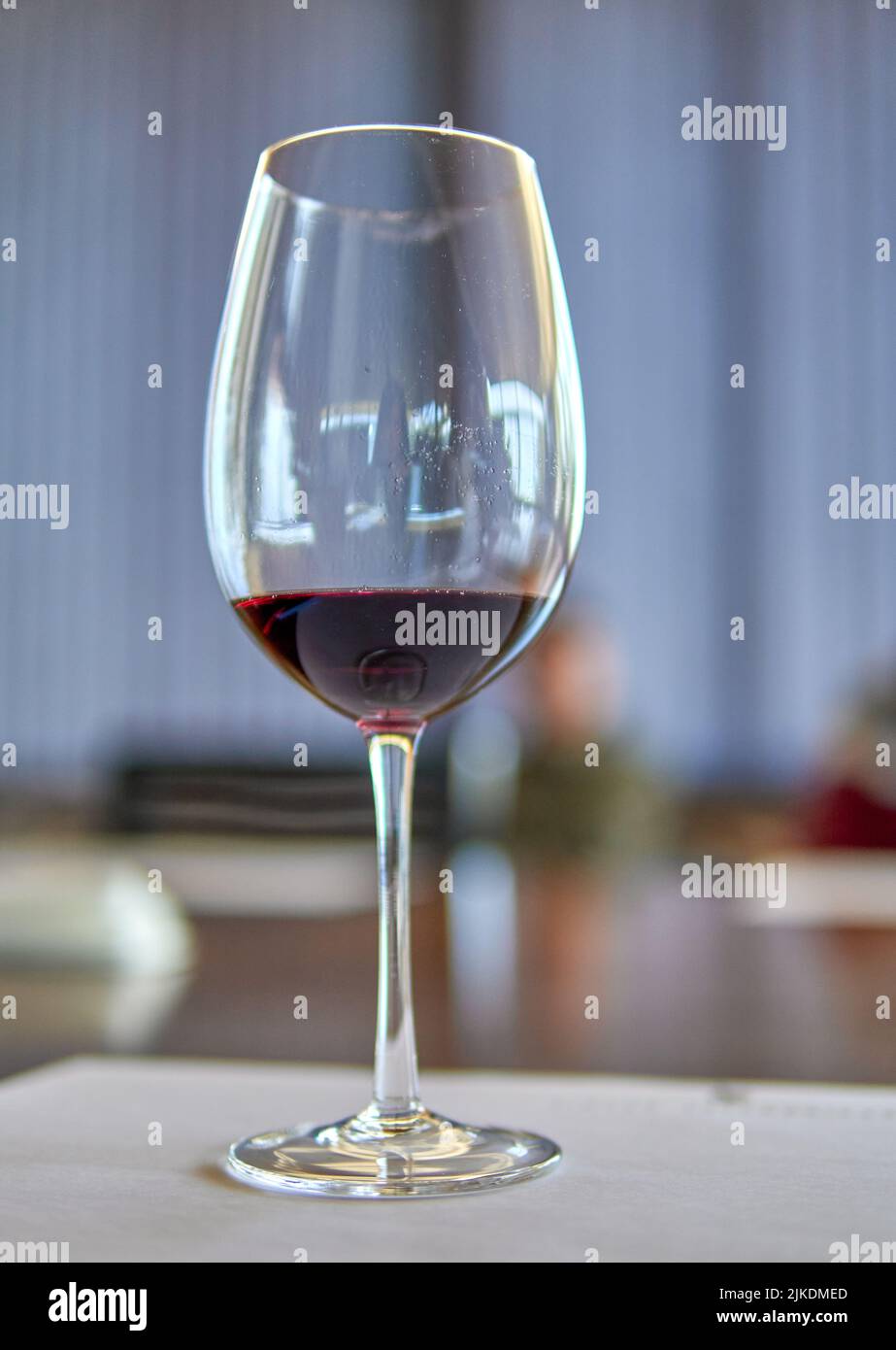Ein Glas Rotwein im Vordergrund, der Hintergrund in einem Weinkeller in Mendoza Argentinien. Weinprobe. Selektiver Fokus Stockfoto
