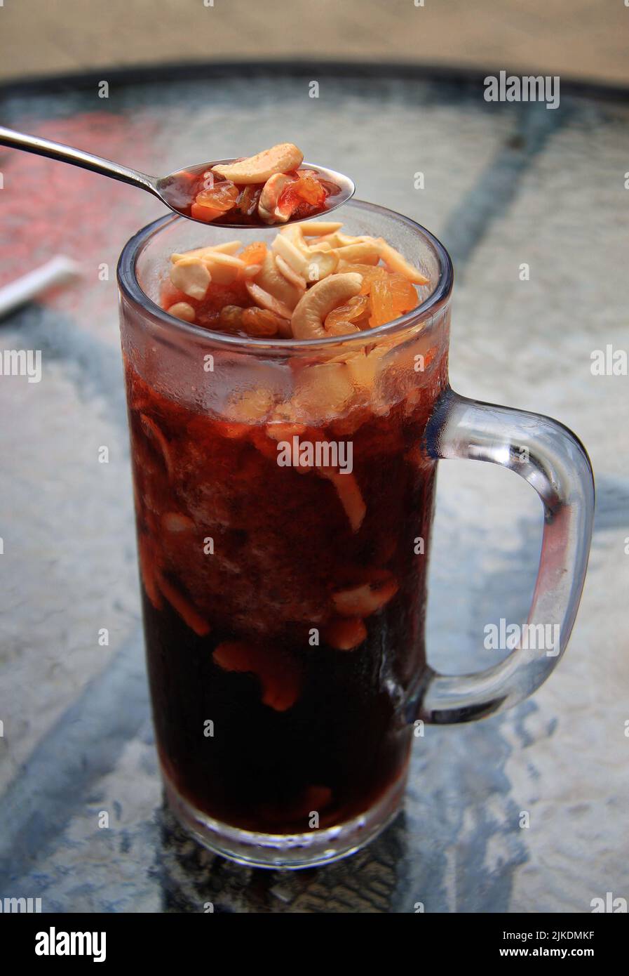 Eine Tasse kalter Jallab mit Rosinen, Cashews und Mandeln. Stockfoto
