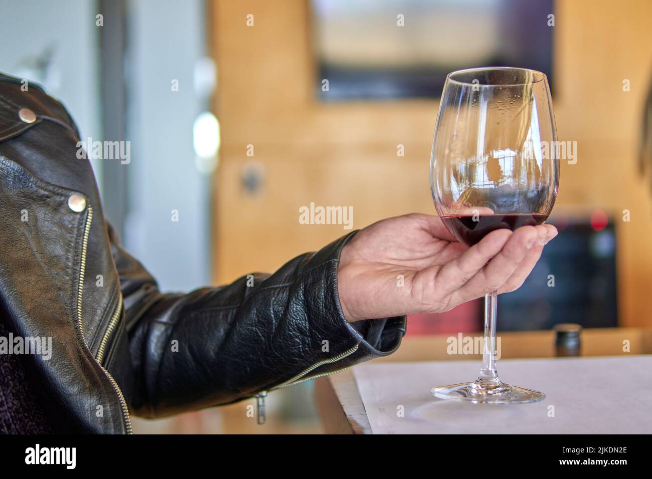 Mann hält ein Glas Rotwein in der Hand. Besuch einer Weinkellerei in mendoza, argentinien. Weinprobe. Selektiver Fokus Stockfoto