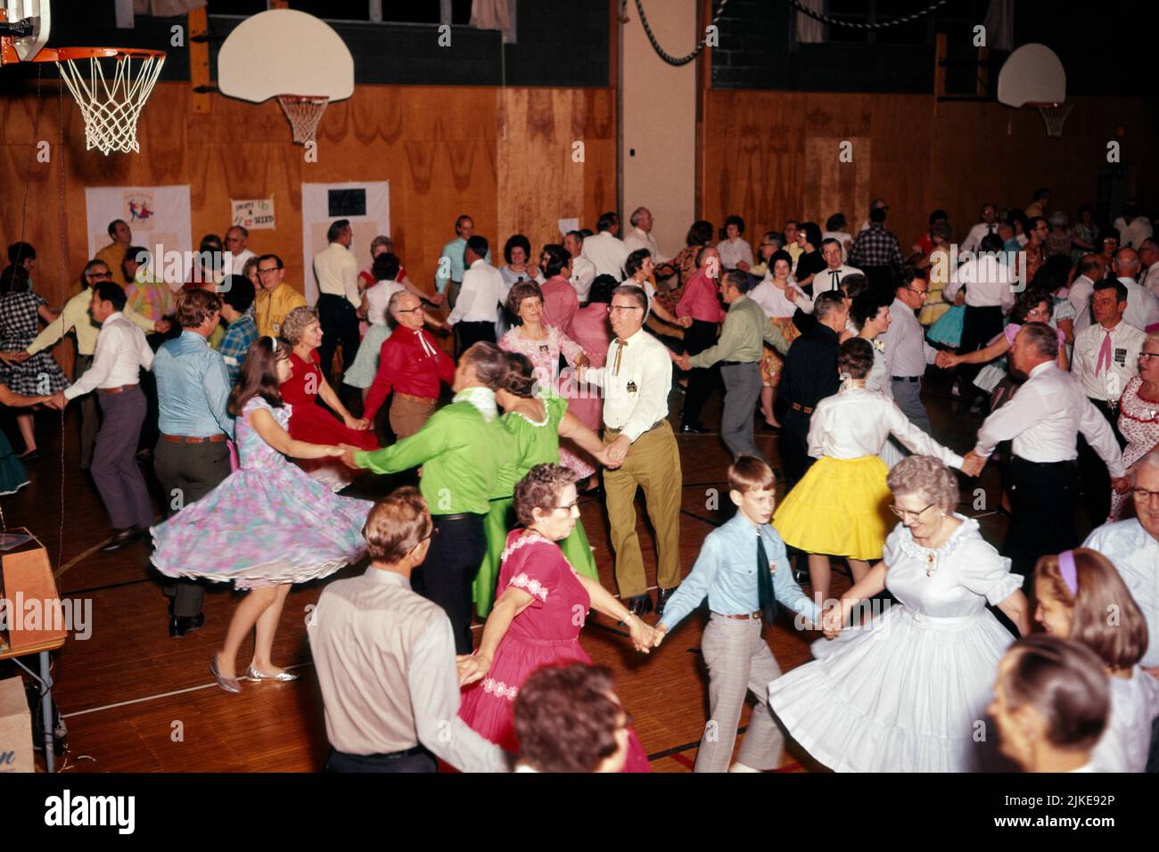 1950S 1960'S GRUPPE VON JUNGEN UND ALTEN MÄNNERN UND FRAUEN WESTERN SQUARE TANZEN IN EINEM GYMNASIUM MIT SPASS - KD2633 SHE001 HARS FARBE SENIOREN TÄNZER ALTE ZEIT BESCHÄFTIGT NOSTALGIE GUTE ALTE MODE PLATZ FITNESS MIT VIELEN STIL WILLKOMMEN KOMMUNIKATION GESUNDES GLEICHGEWICHT TEAMWORK FIT FREUDE LIFESTYLE GESCHWINDIGKEIT FEIER ÄLTERE FRAUEN LÄNDLICH ERWACHSEN GESUNDHEIT HORIZONTAL KOPIEREN RAUM FREUNDSCHAFT GANZKÖRPERFRAUEN KÖRPERLICHE FITNESS PERSONEN INSPIRATION ERWACHSENE FÜRSORGLICHE MÄNNER WESTERN ENTERTAINMENT CONFIDENCE WEITWINKEL-AKTIVITÄT GLÜCK KÖRPERLICHE GESUNDHEIT IM ALTER ALT HOCH ANGLE OLDSTER FREIZEIT STÄRKE Stockfoto