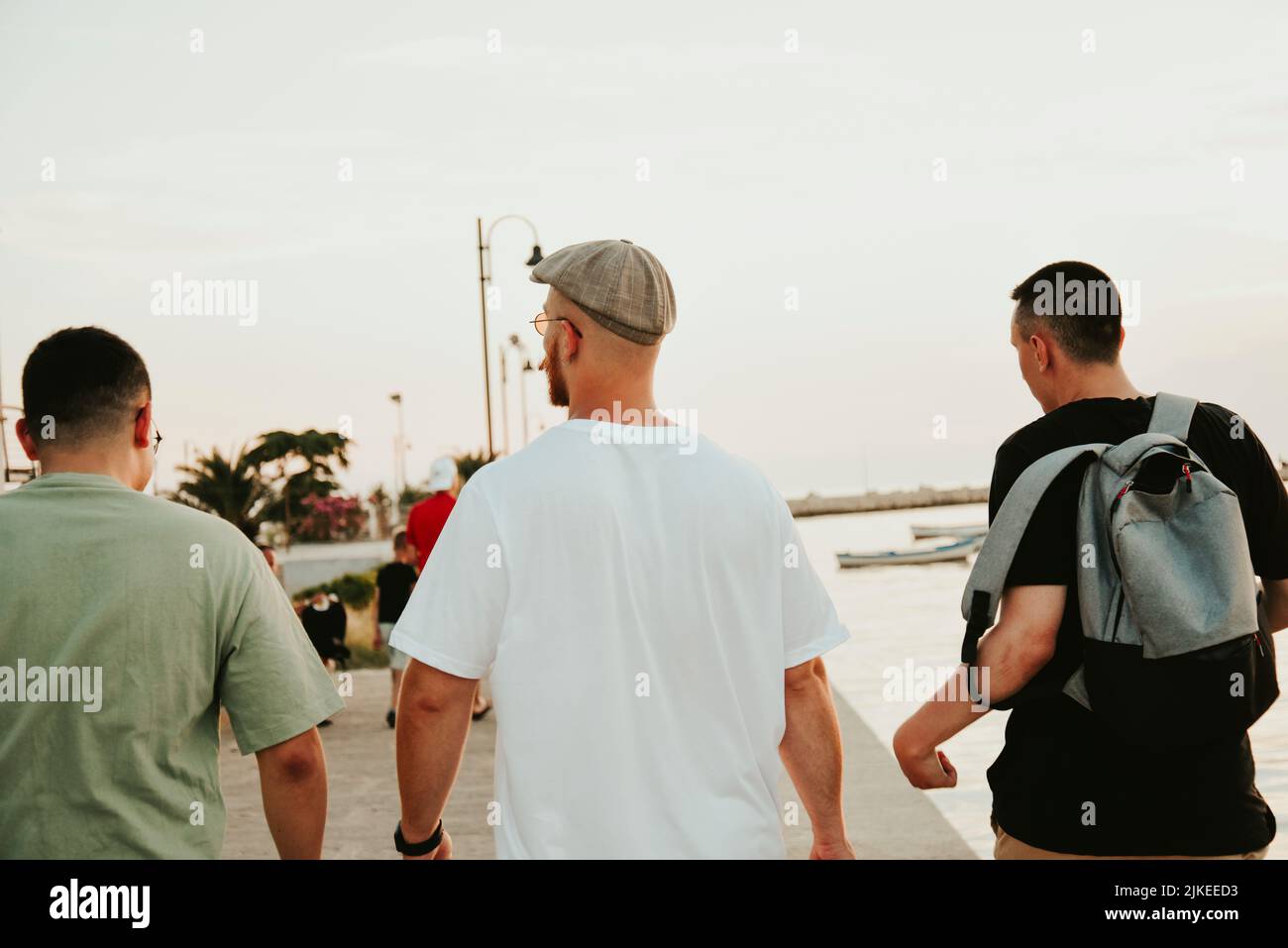 Eine Gruppe von Freunden spazieren am Meer entlang. Stimmungsvolles Urlaubsfoto. An Wochenenden Stockfoto