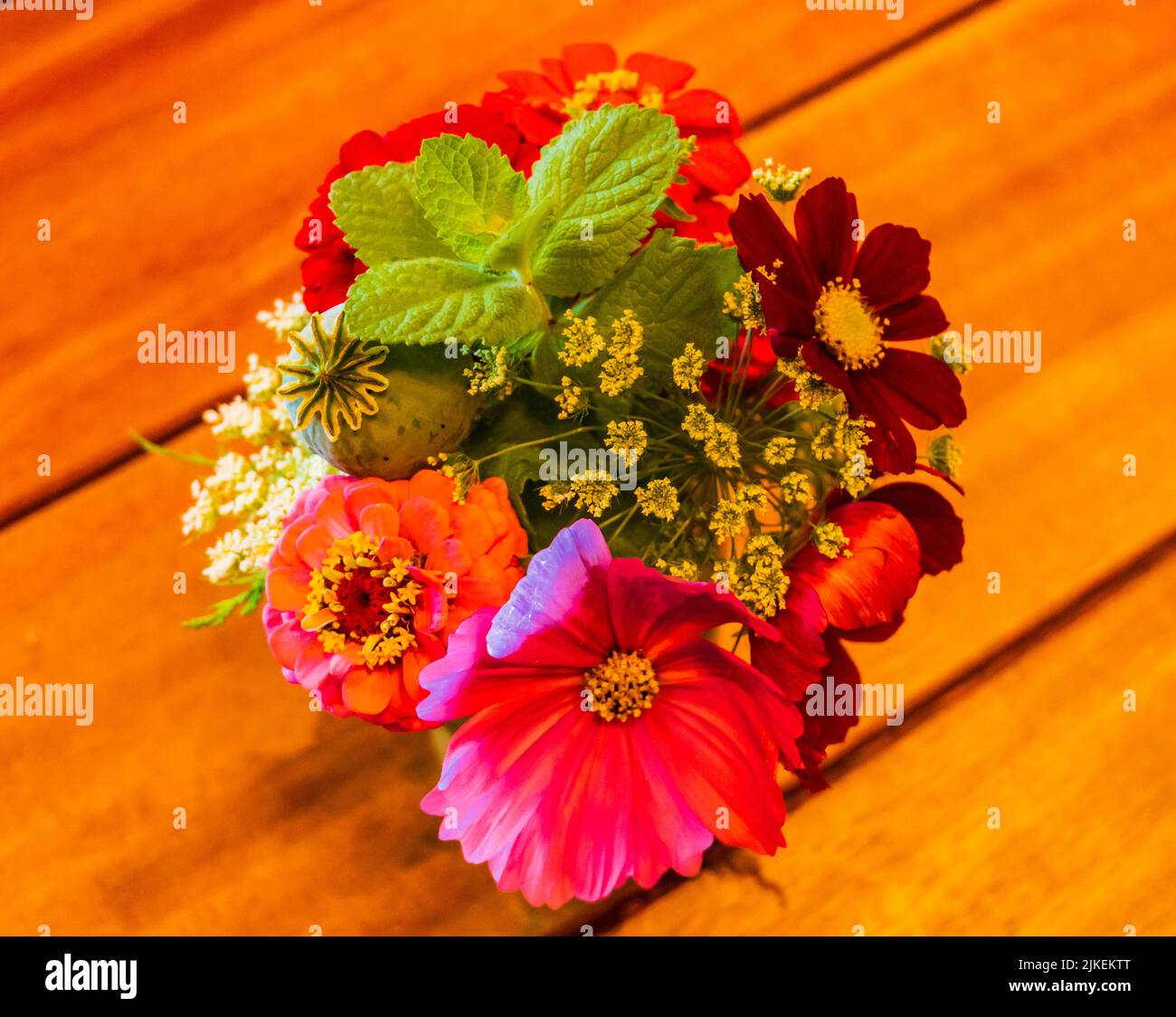 Kleiner Strauß von Gartenblumen Zinnien, Kosmos und Wildblumen auf dem Tisch Stockfoto