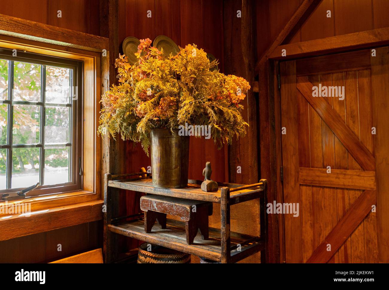 Schöne hölzerne Innenausstattung des Bauernhofes mit einem großen getrockneten Gras und Blumenarrangement Stockfoto