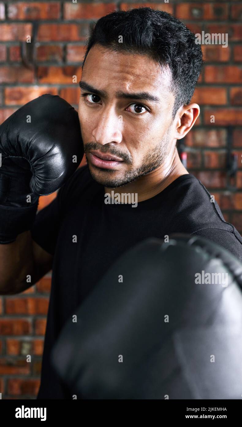 Fordern Sie sich jeden Tag der Woche heraus. Nahaufnahme eines jungen Mannes mit Boxhandschuhen. Stockfoto