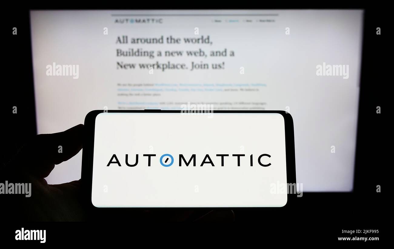 Person, die das Smartphone mit dem Logo des US-amerikanischen Distributed Company Automattic Inc. Auf dem Bildschirm vor der Website hält. Konzentrieren Sie sich auf die Telefonanzeige. Stockfoto