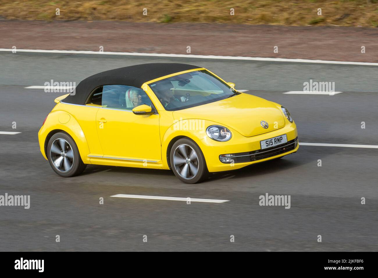 2015 gelber VW Volkswagen Beetle 1197cc 6-Gang Schaltgetriebe Cabrio; fahrend, fahrend, fahrend, fahrend, fahrend auf der Autobahn M6, UK Stockfoto