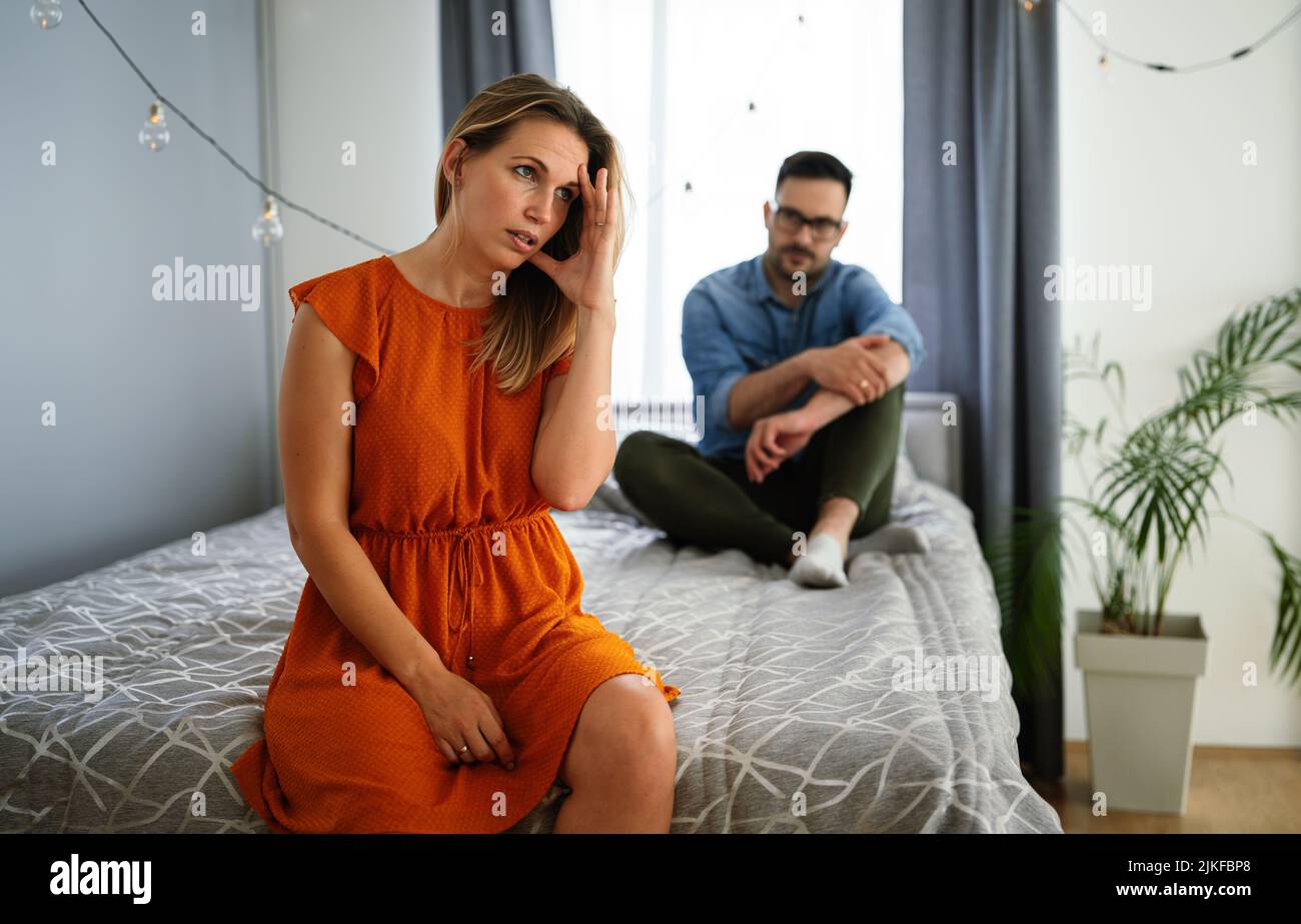 Traurige, nachdenkliche Paare, die an Beziehungsprobleme denken, die auf dem Sofa sitzen, Konflikte in der Ehe. Stockfoto