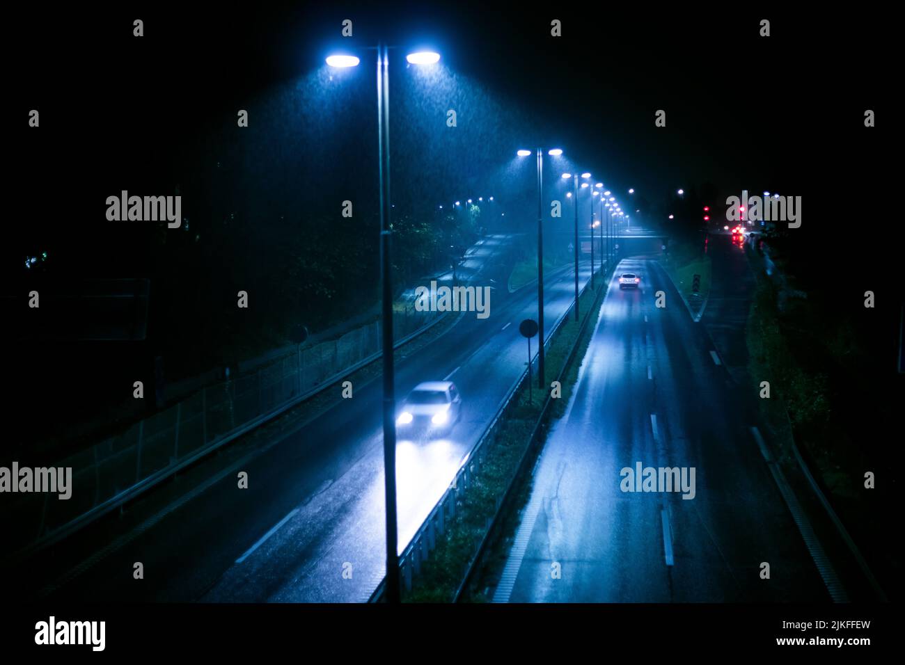 Regnerische, stimmungsvolle Nacht auf der Gentofte Jaegersborg Straße, Dänemark Stockfoto